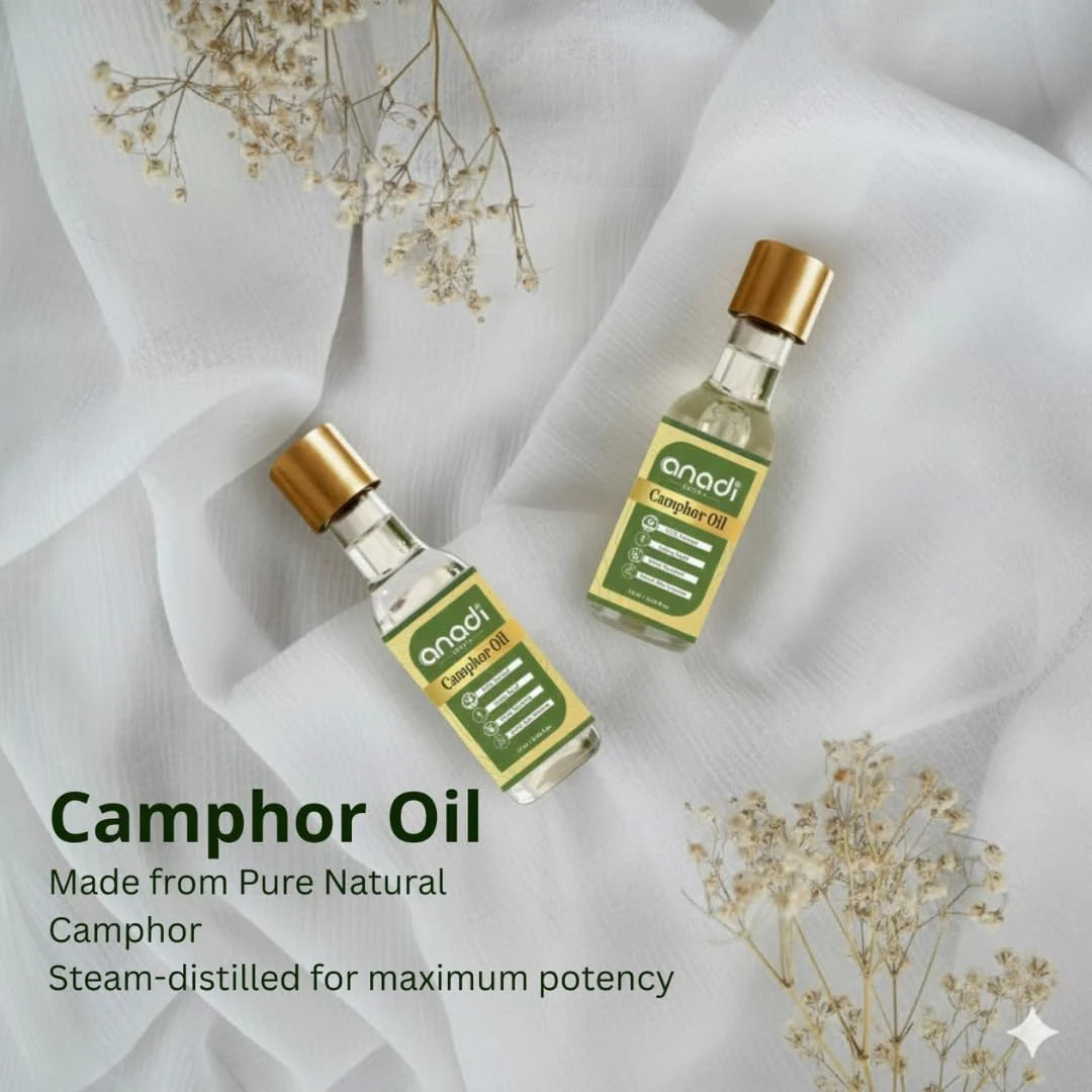 Two camphor oil bottles with gold caps, clear glass and green labels on white fabric