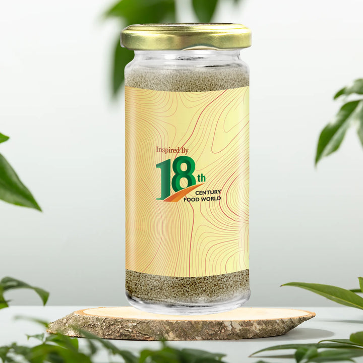 Glass jar of poppy seeds with gold lid and cream label featuring 18th Century Food World